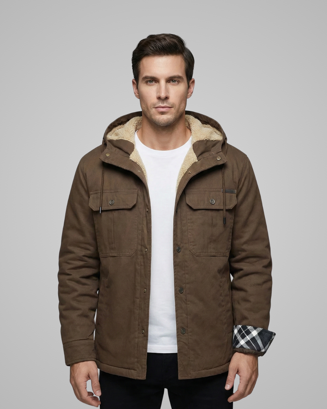 Man wearing a brown jacket with a hood on a gray background