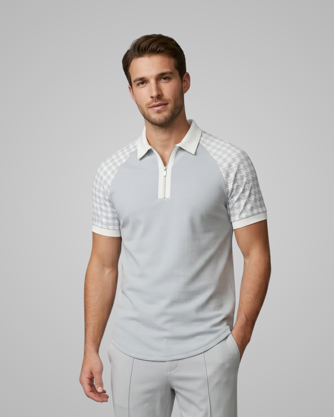 Man wearing a light gray polo shirt with white checkered sleeves on a gray background