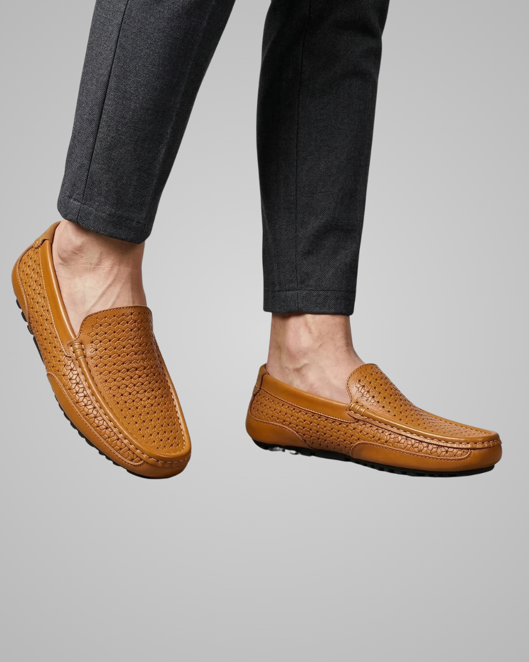 Brown loafers worn with dark pants on a gray background