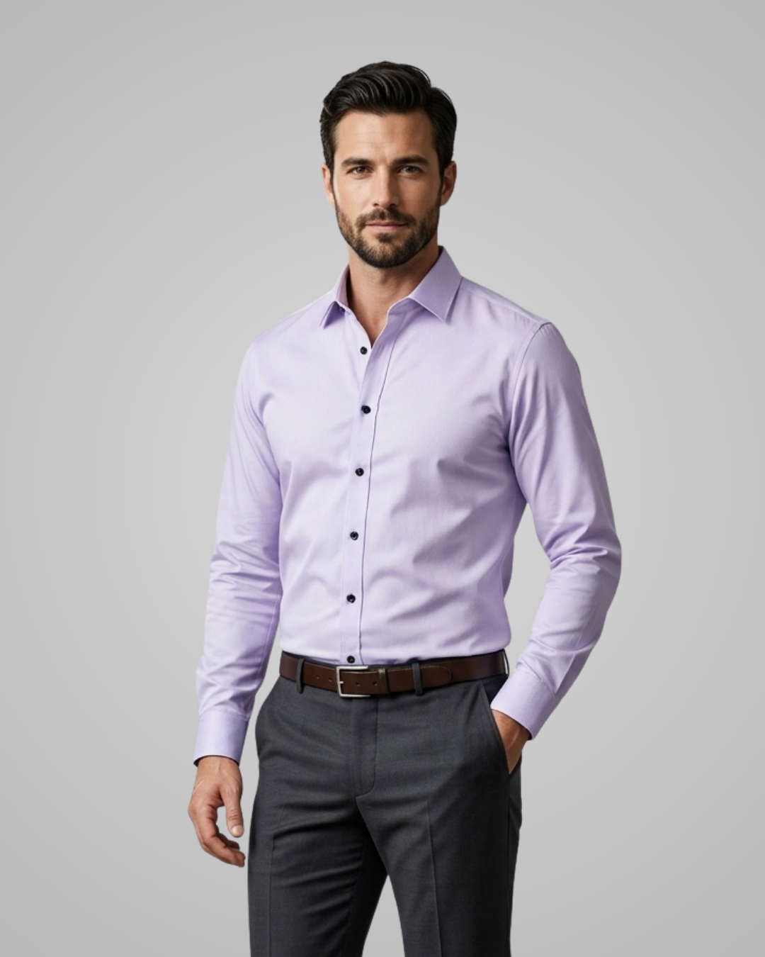 Man wearing a light purple dress shirt and gray pants on a gray background
