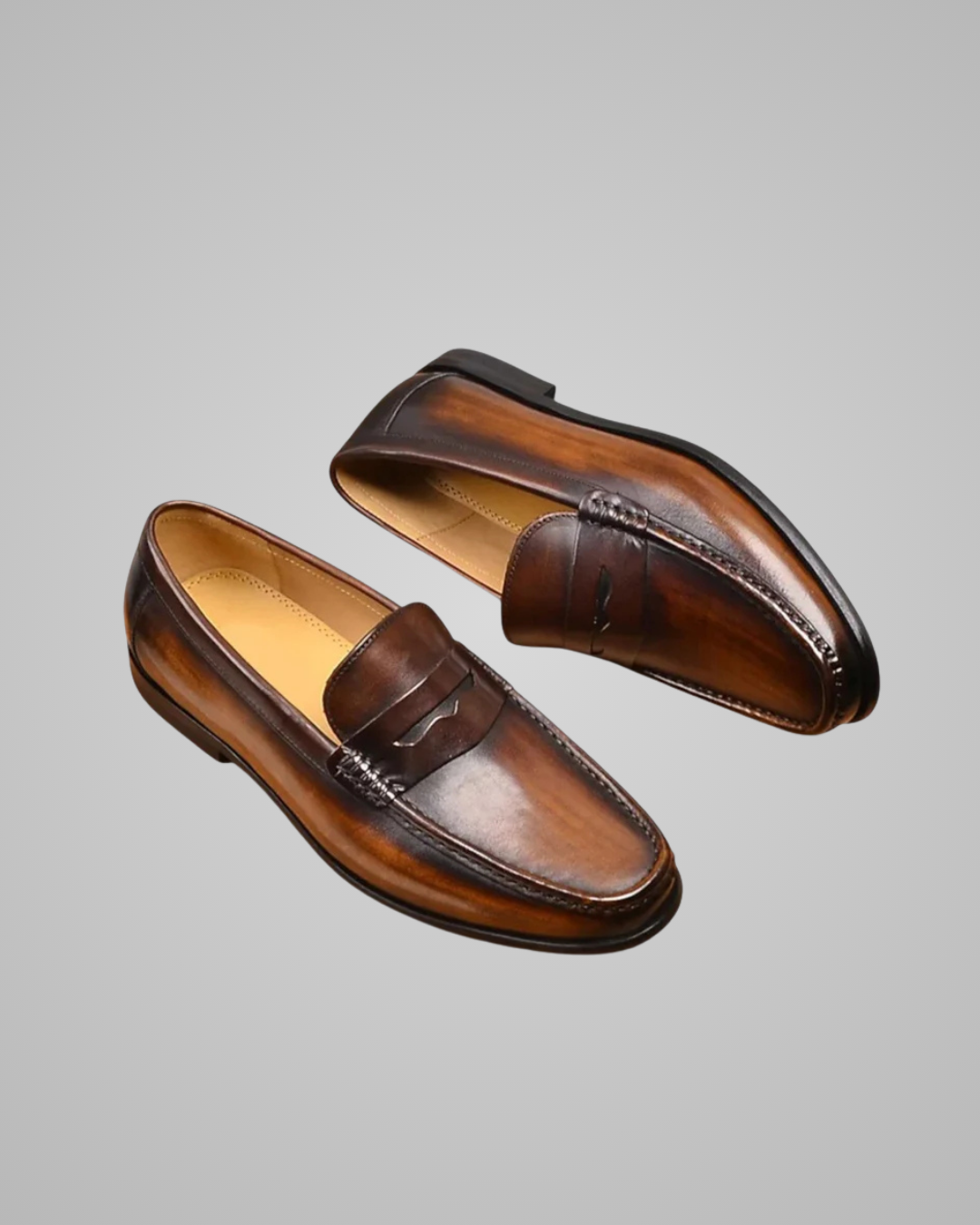 Pair of brown leather loafers on a gray background