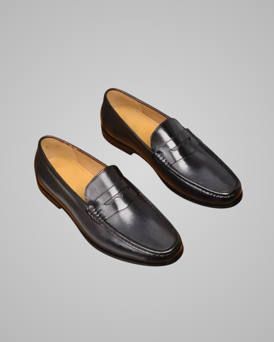 Pair of black loafers on a gray background