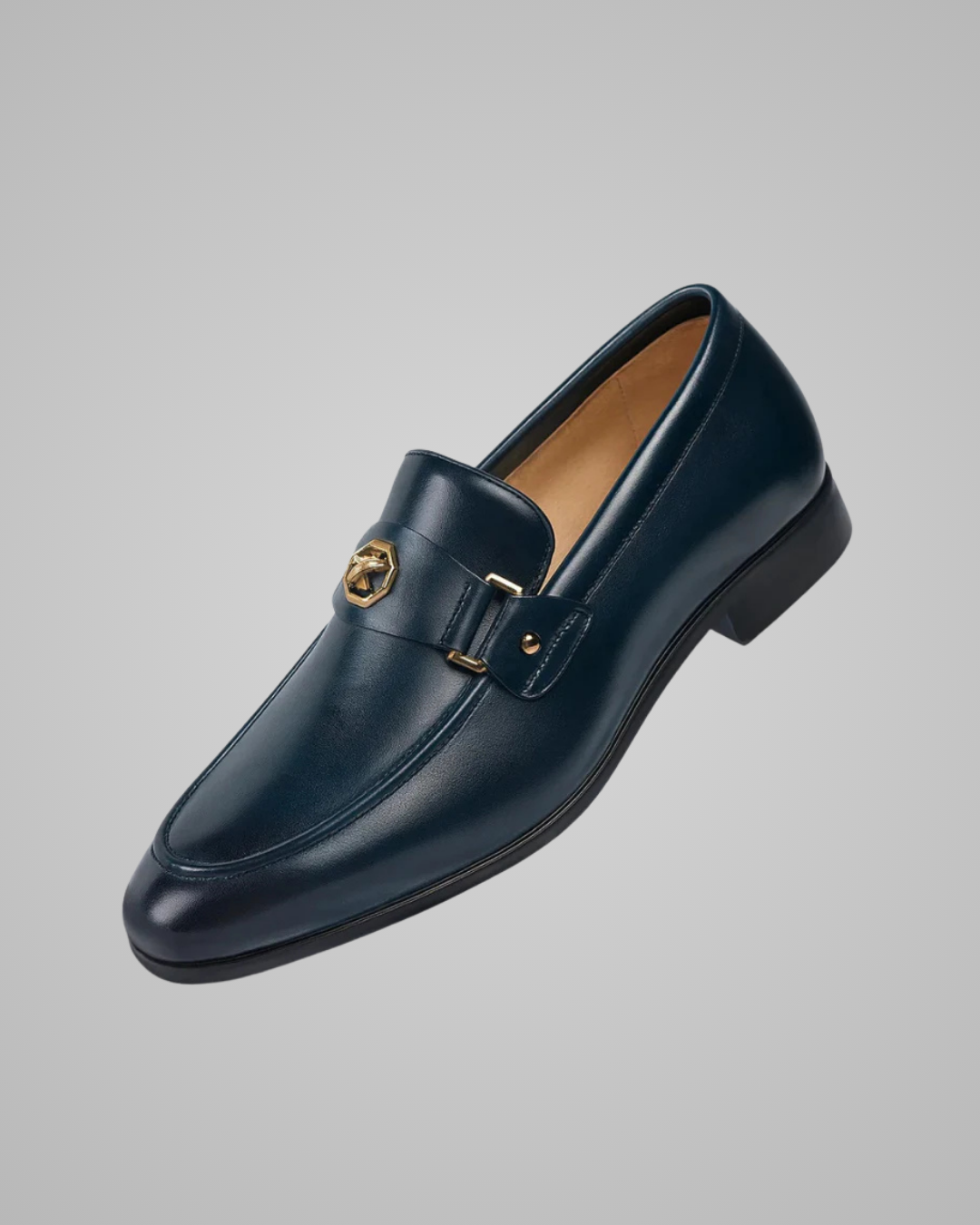 Navy blue loafer with gold buckle on a gray background
