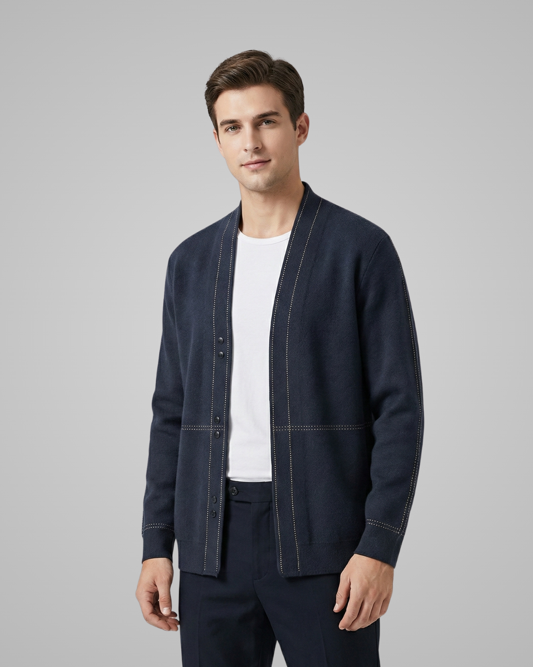 Man wearing a navy blue jacket over a white shirt on a gray background