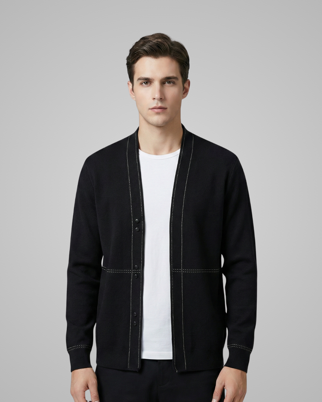 Man wearing a black jacket over a white shirt on a gray background