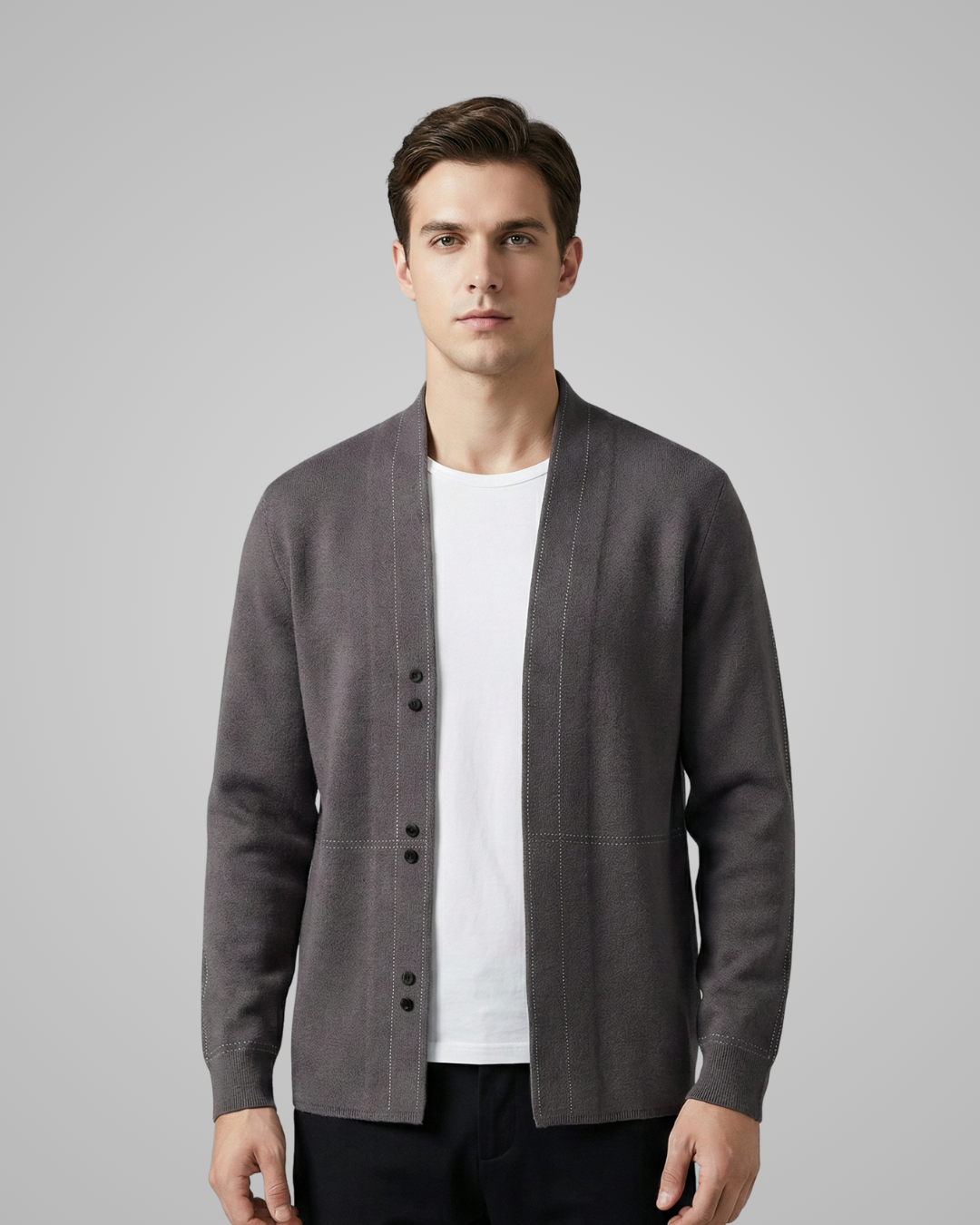 Man wearing a gray cardigan over a white shirt on a gray background