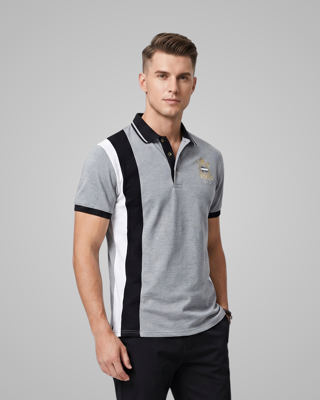 Man wearing a grey polo shirt with black and white accents and a logo on a gray background