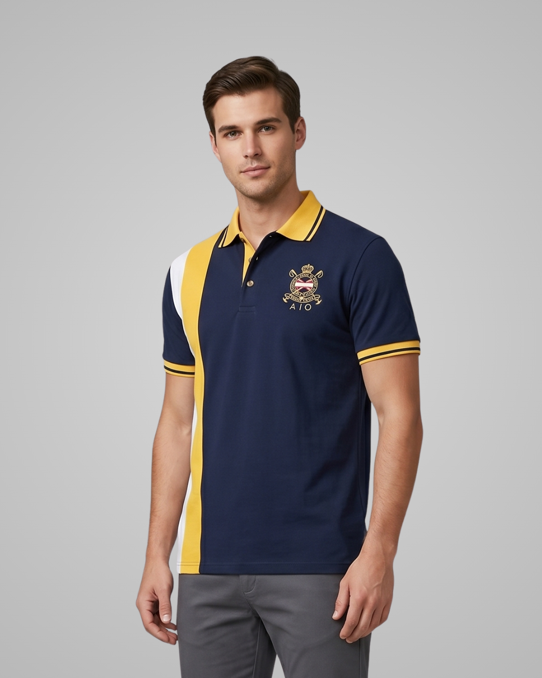 Man wearing a navy blue polo shirt with yellow and white accents and a logo on a gray background
