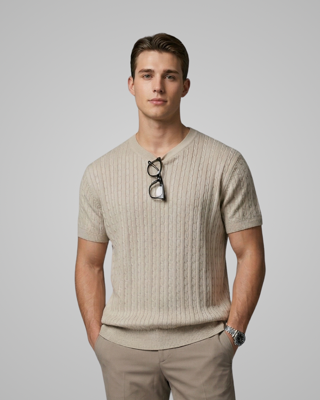 Man wearing a beige ribbed sweater with sunglasses on a gray background