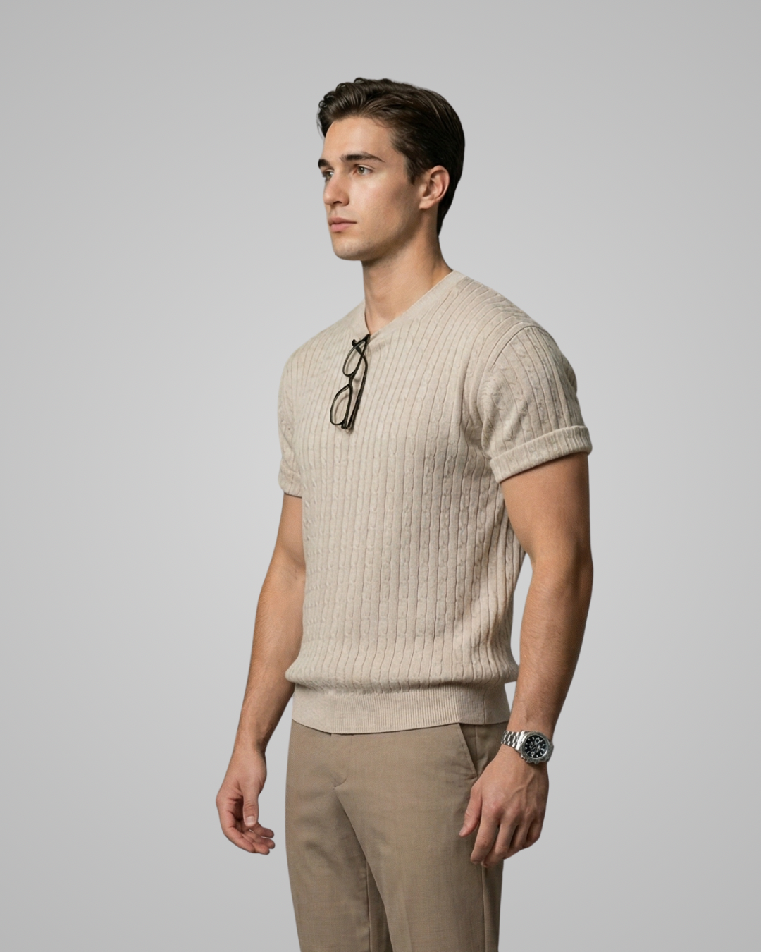 Man wearing a beige ribbed sweater and pants against a plain background