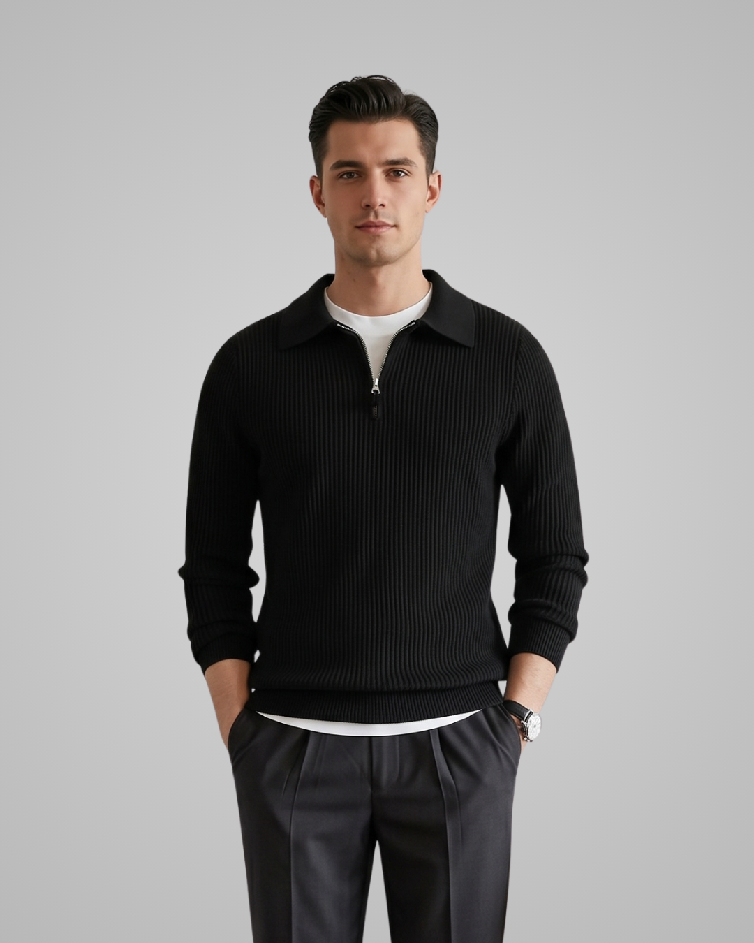 Man wearing a black ribbed sweater over a white shirt on a gray background