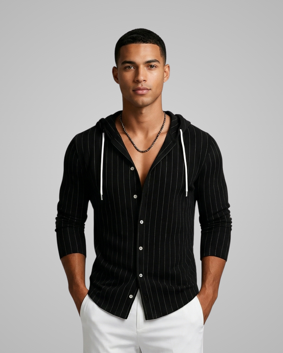 Man wearing a black pinstripe hoodie with white pants on a gray background
