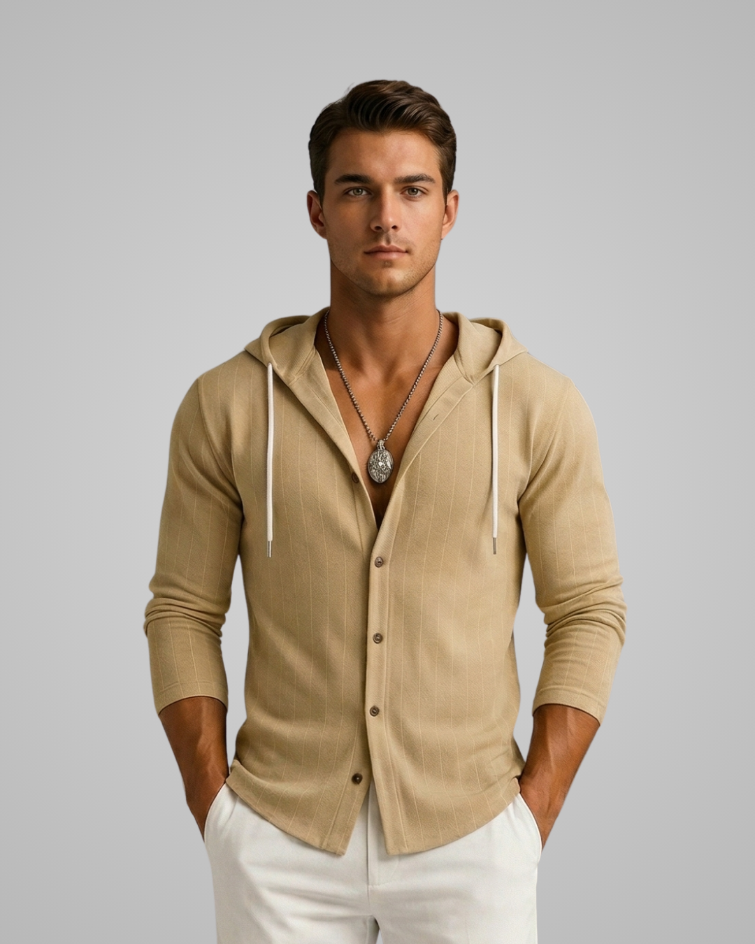 Man wearing a beige hoodie with white pants on a gray background