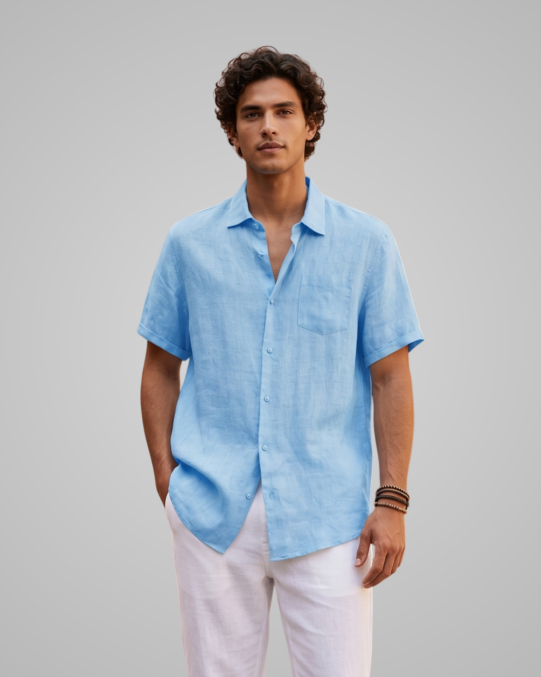 Man wearing a light blue short-sleeve shirt and white pants against a gray background
