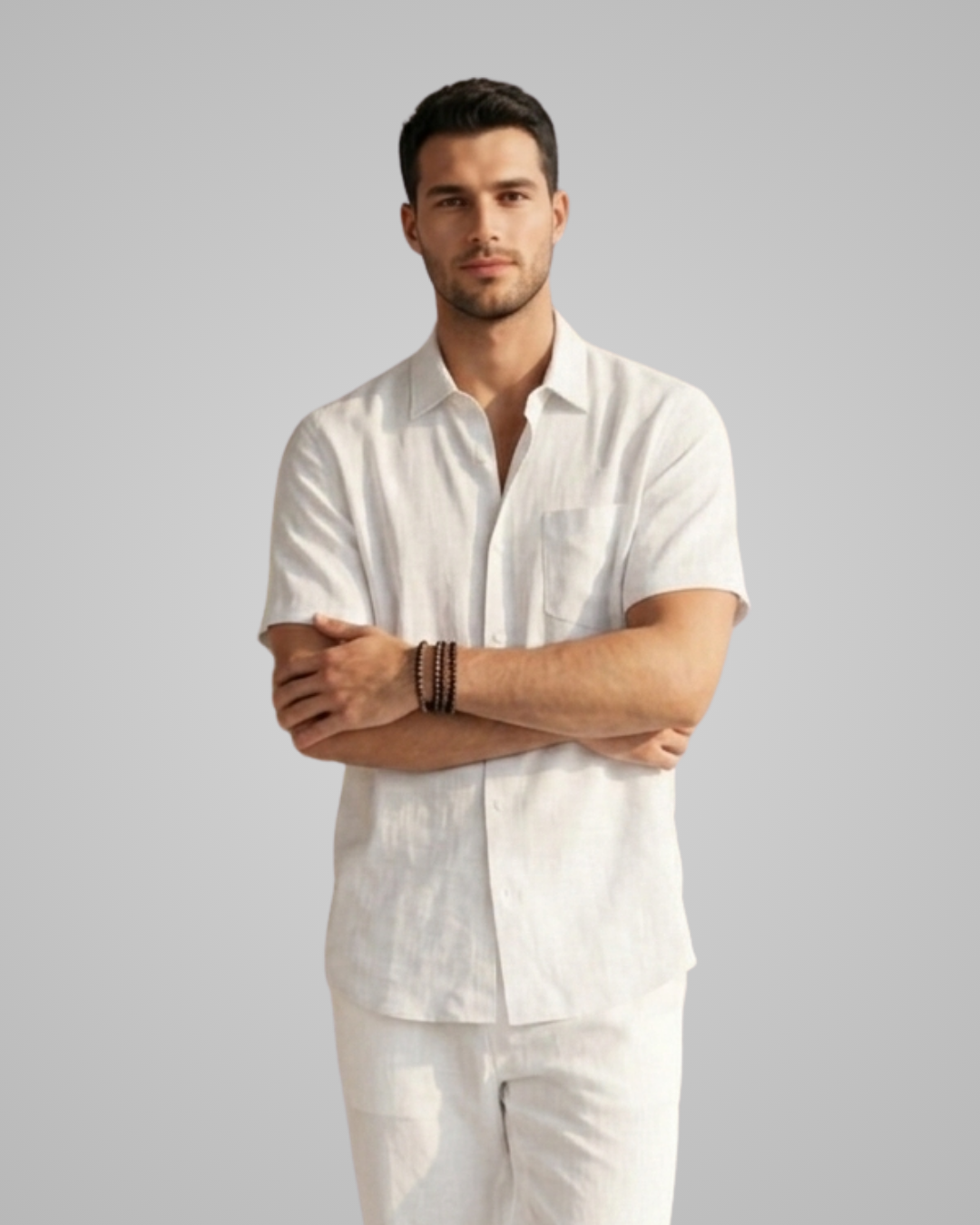Man wearing a white linen shirt and pants against a gray background