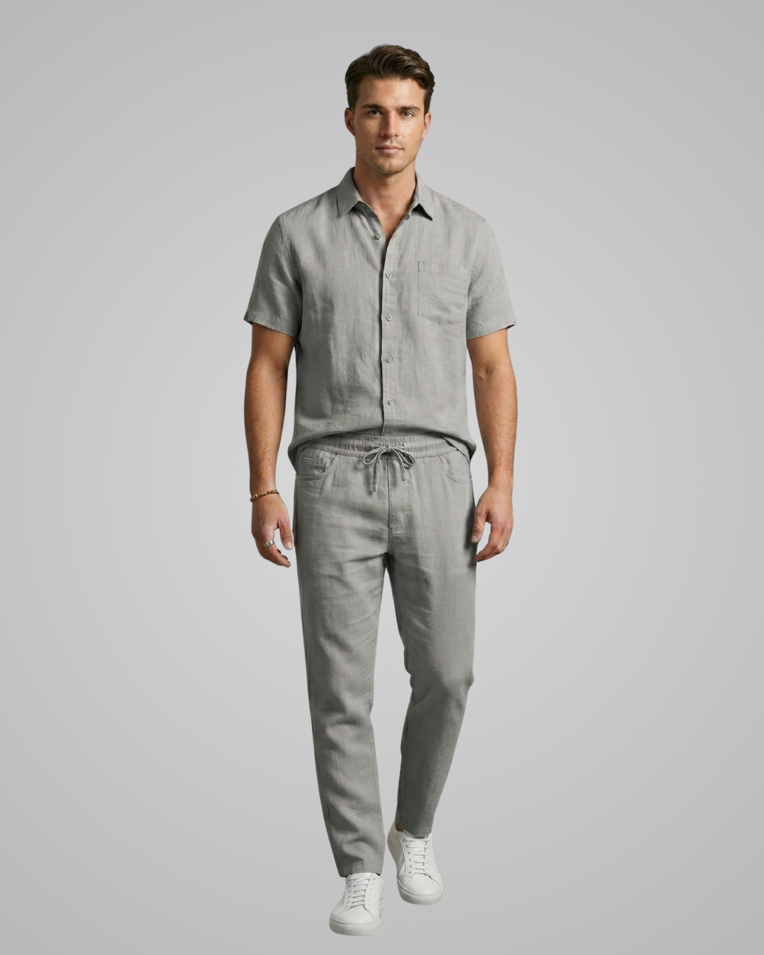 Man wearing a gray shirt and pants on a plain background