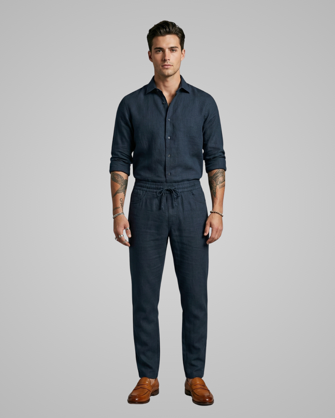 Man wearing a dark blue jumpsuit on a gray background