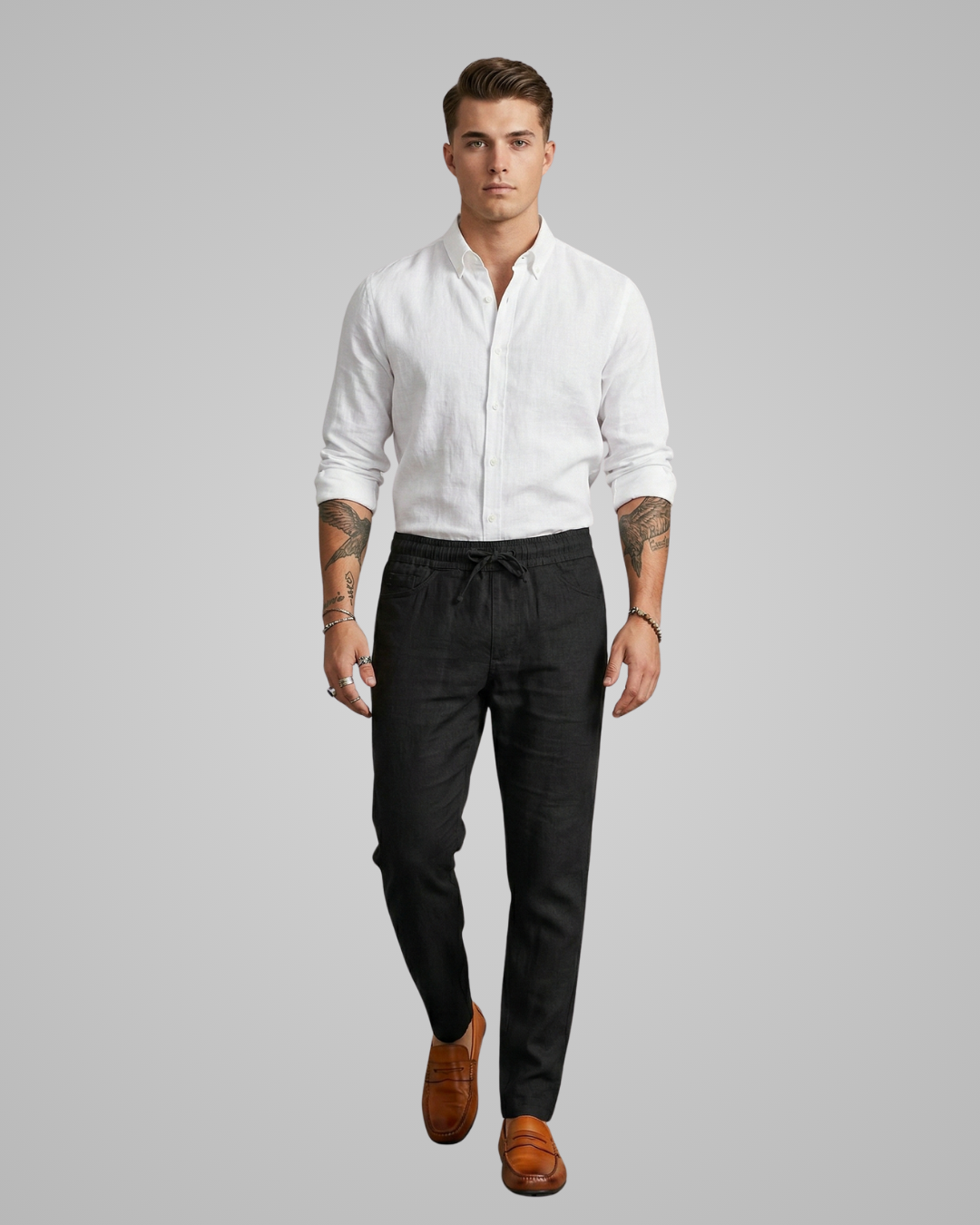 Man wearing a white shirt and black pants on a gray background