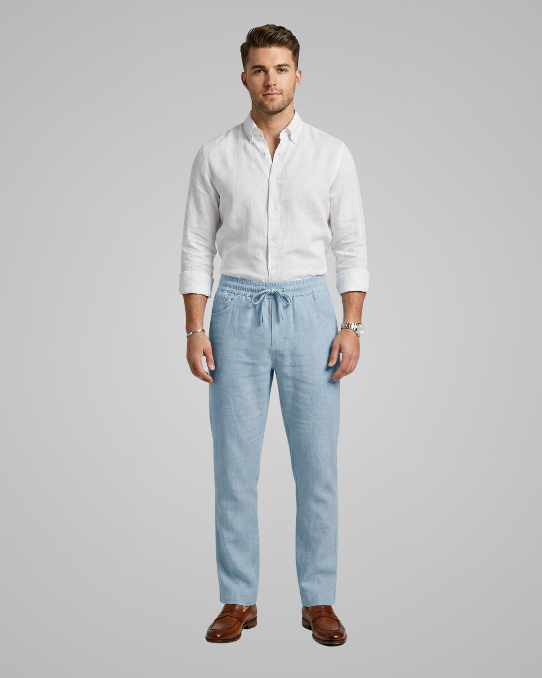 Man wearing a white shirt and light blue pants on a gray background