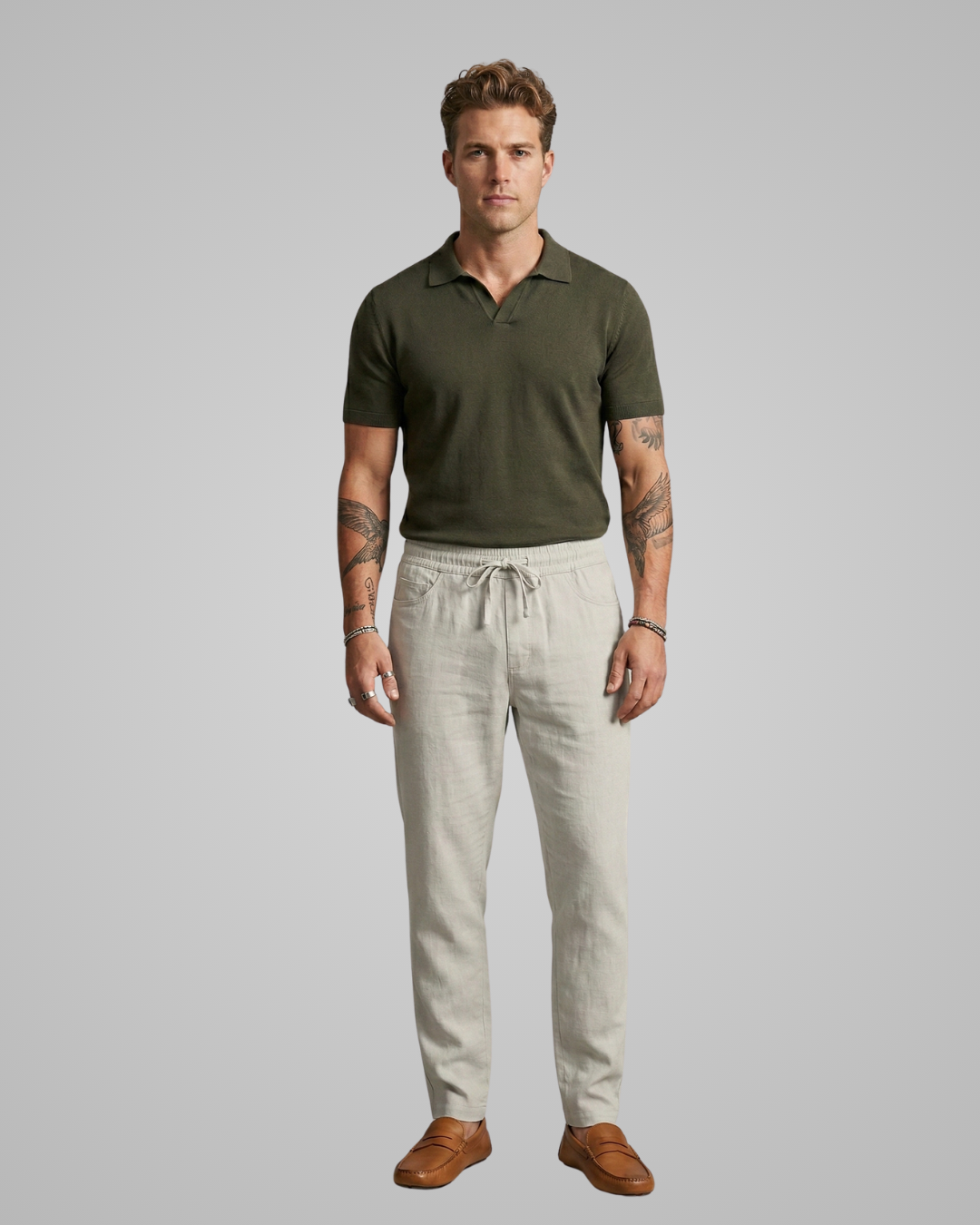 Man wearing a green polo shirt and beige pants on a gray background