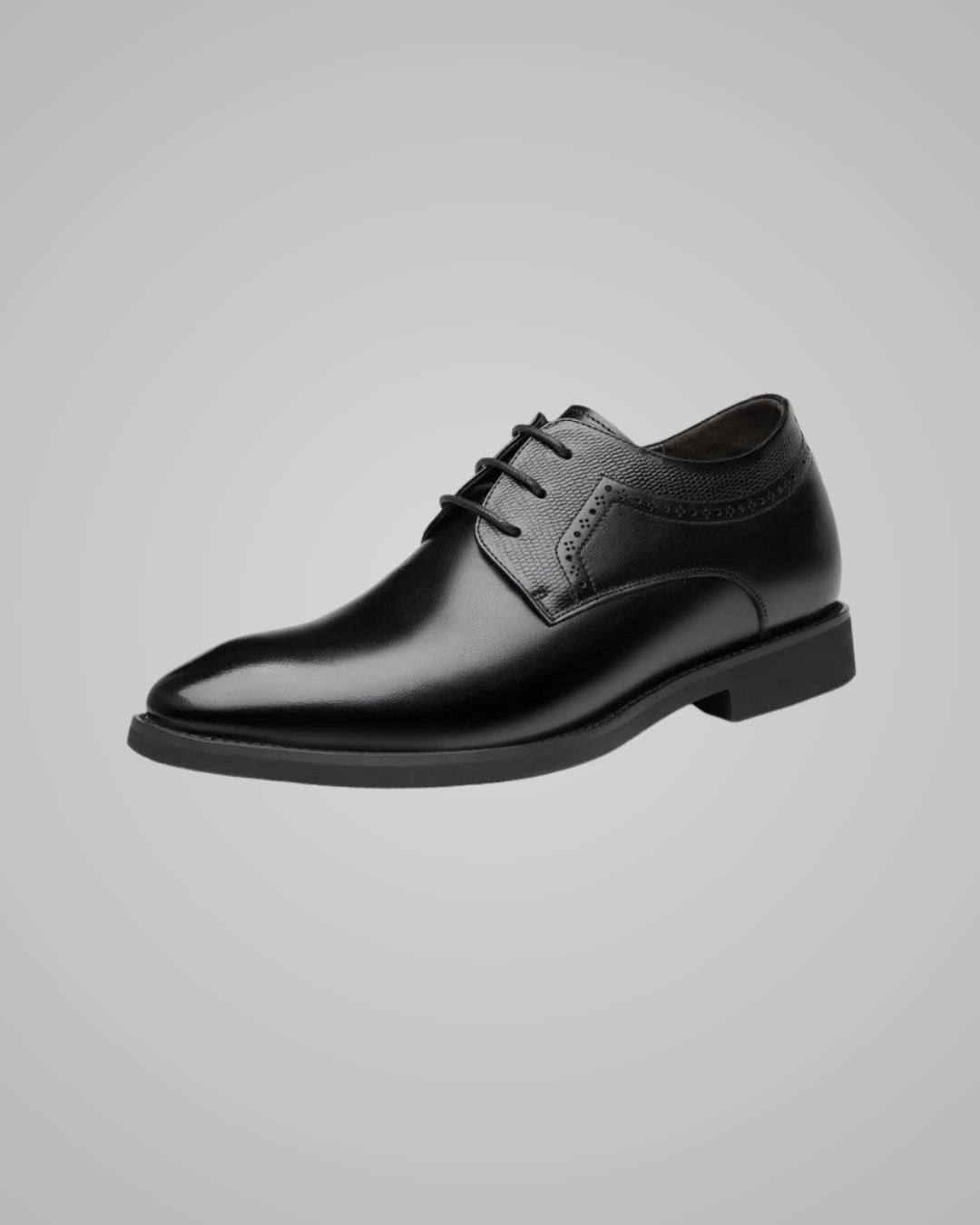 Black dress shoes worn with gray pants on a light gray background