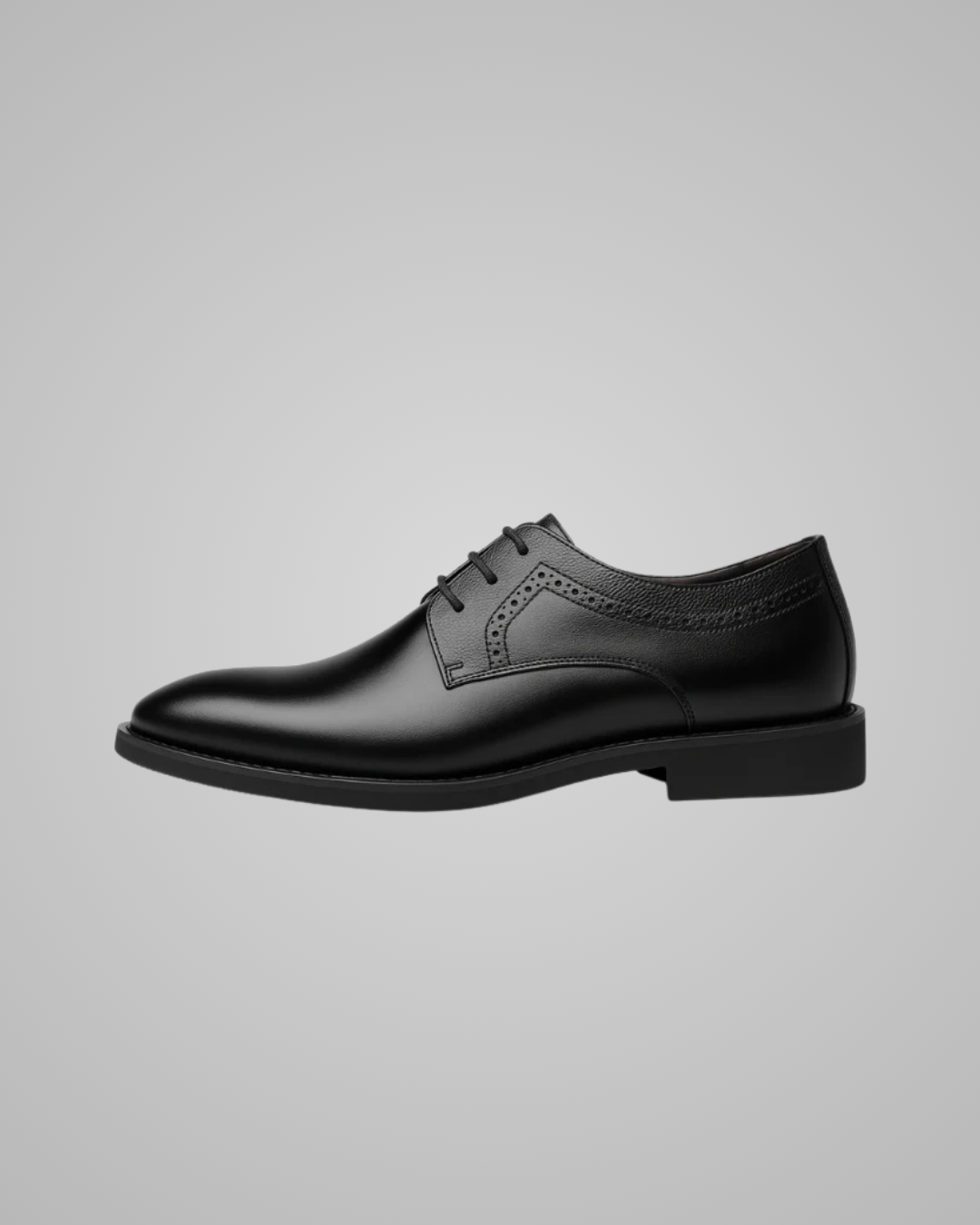Black dress shoes worn with gray pants on a light gray background