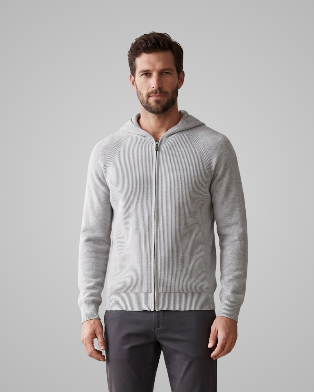 Man wearing a gray zip-up hoodie against a plain background