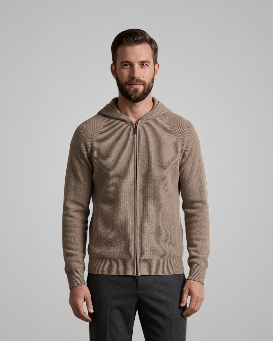 Man wearing a brown zip-up hoodie against a gray background