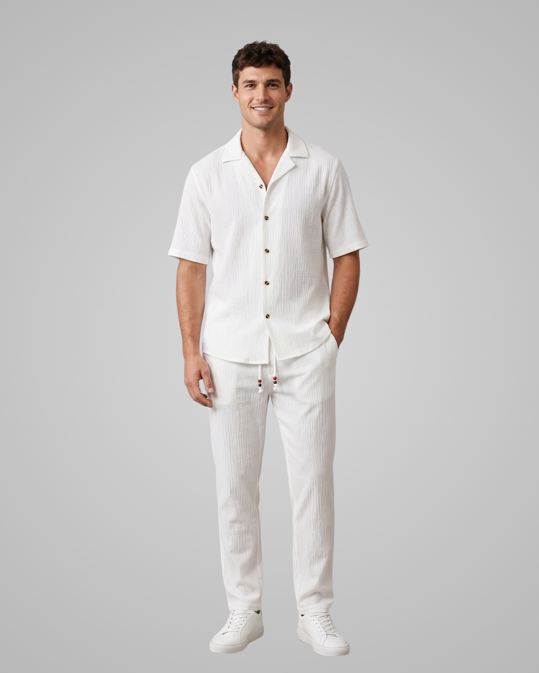 Man wearing a white linen outfit on a gray background