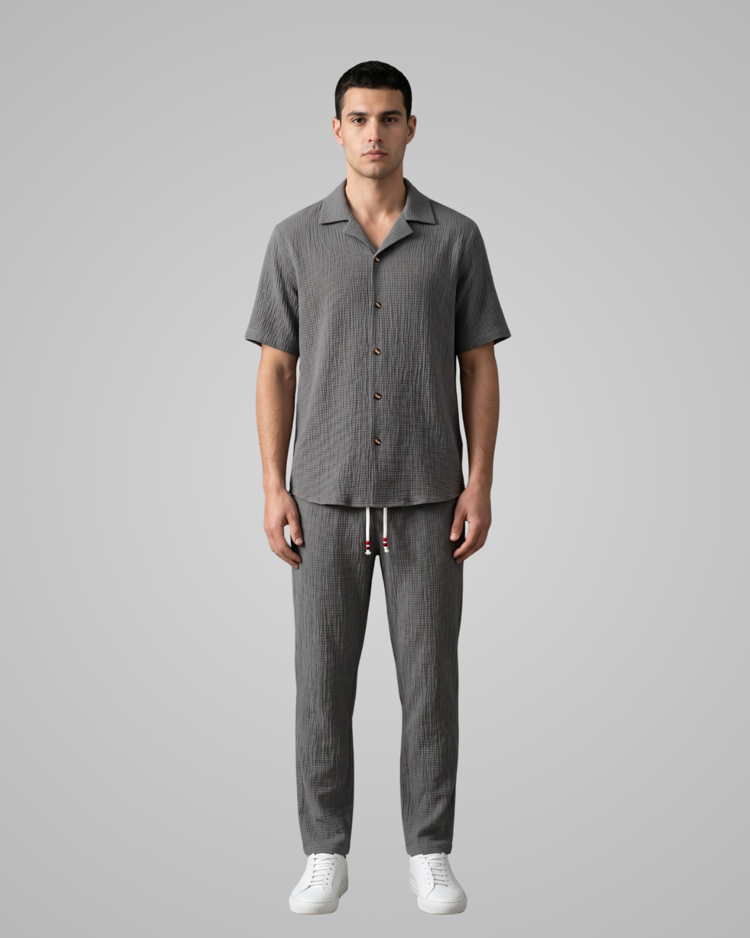 Man wearing a gray checkered outfit on a plain background