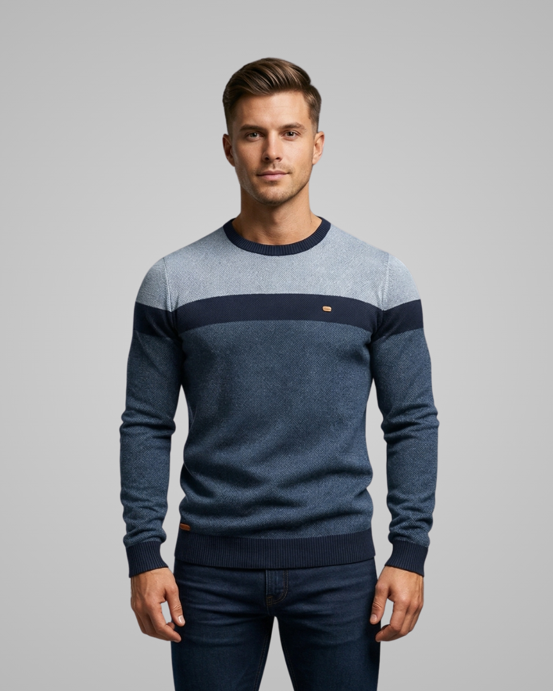 Man wearing a blue and gray sweater with a gray background