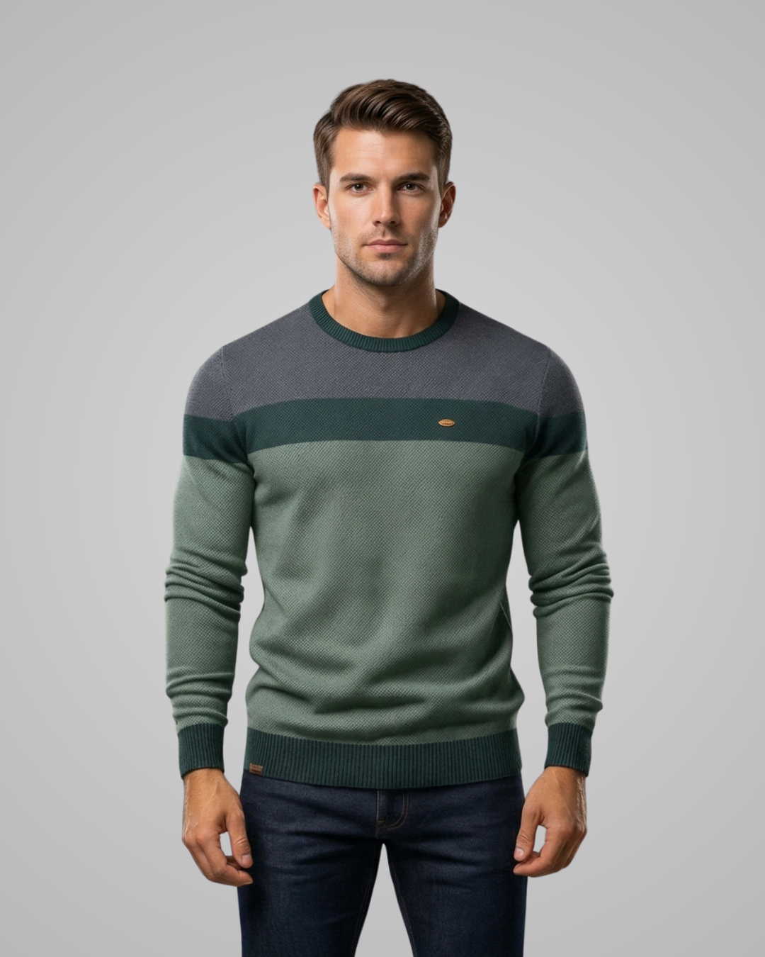 Man wearing a green and gray sweater on a gray background