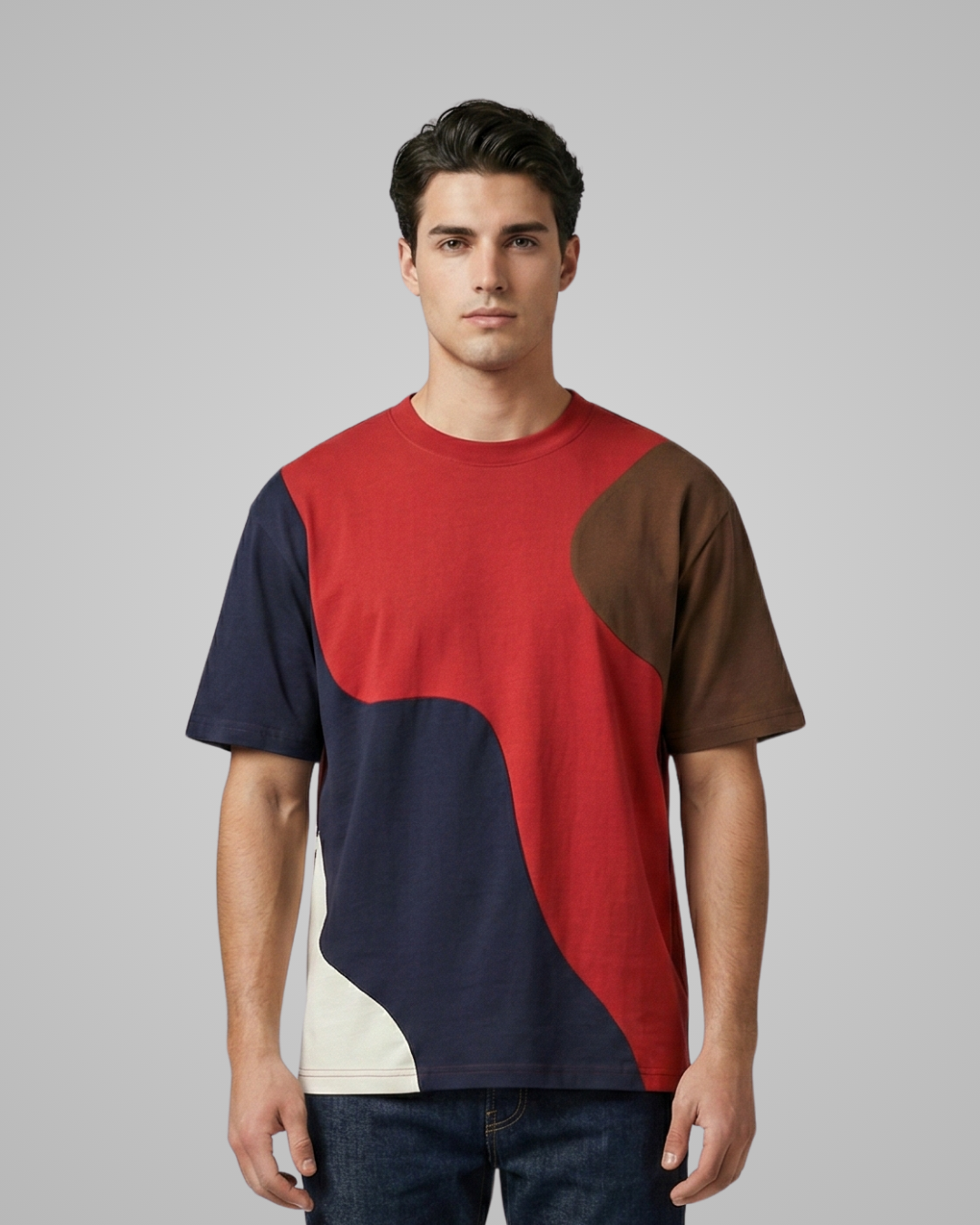 Man wearing a red, navy, and brown color-blocked t-shirt on a gray background
