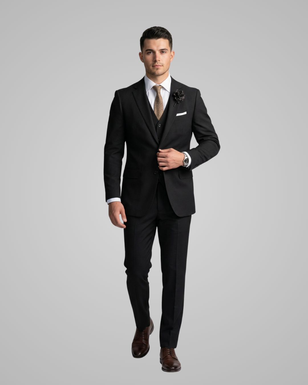 Man wearing a black suit with a white shirt and brown shoes on a gray background