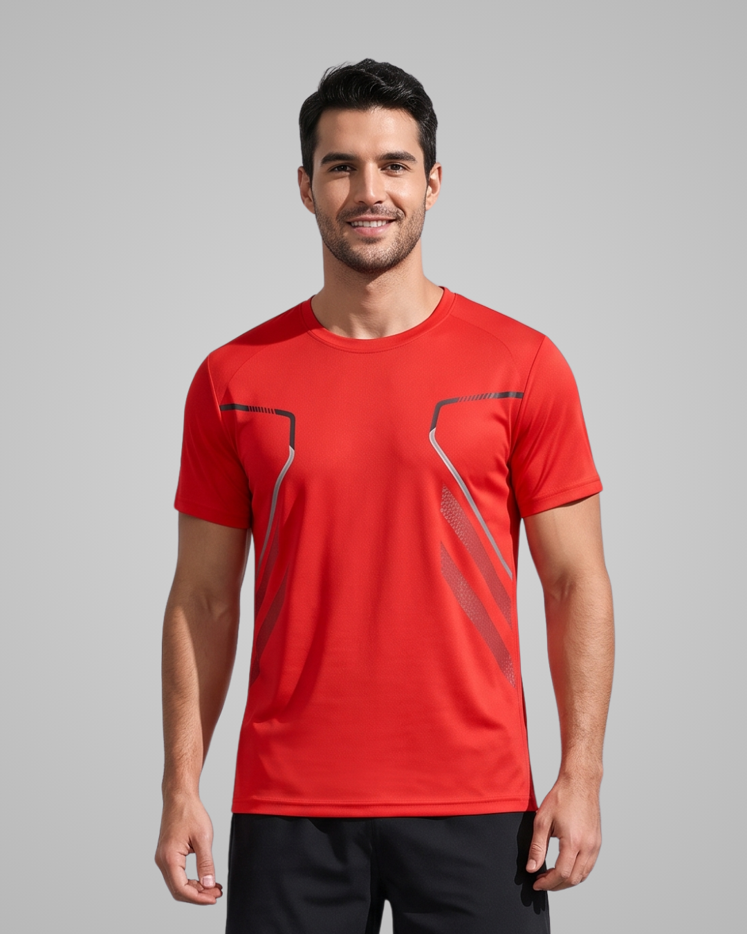 A man wearing a bright red short-sleeve athletic t-shirt with dark gray geometric line accents on the chest, posed against a solid gray studio background.