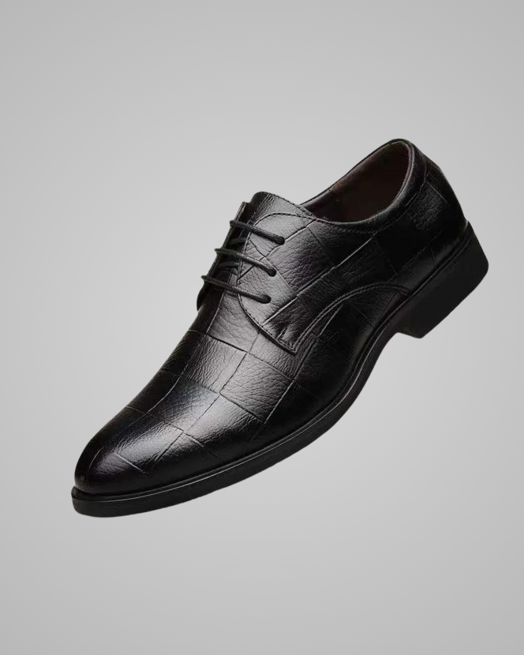 Black leather dress shoe on a gray background