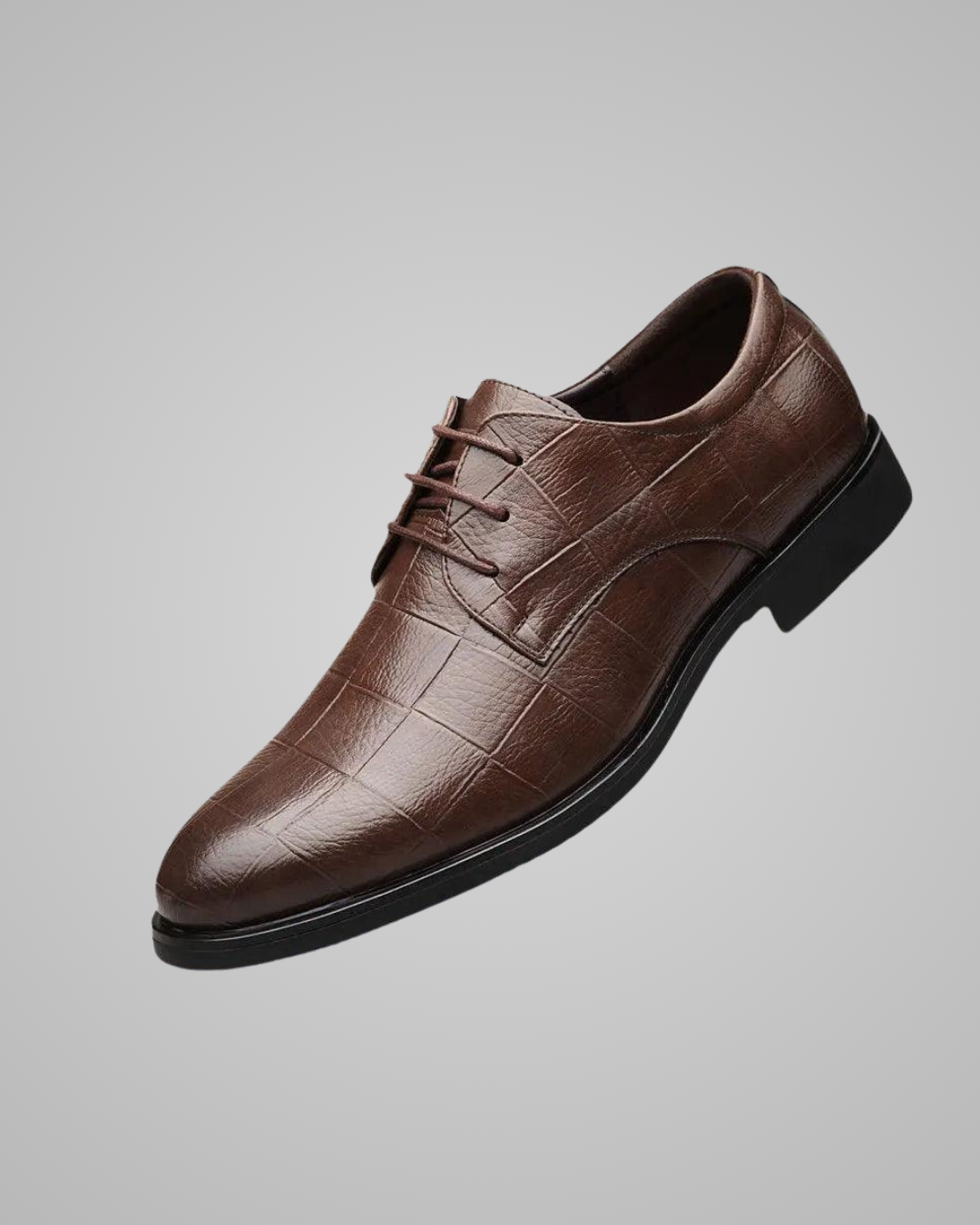 Brown leather dress shoe on a gray background