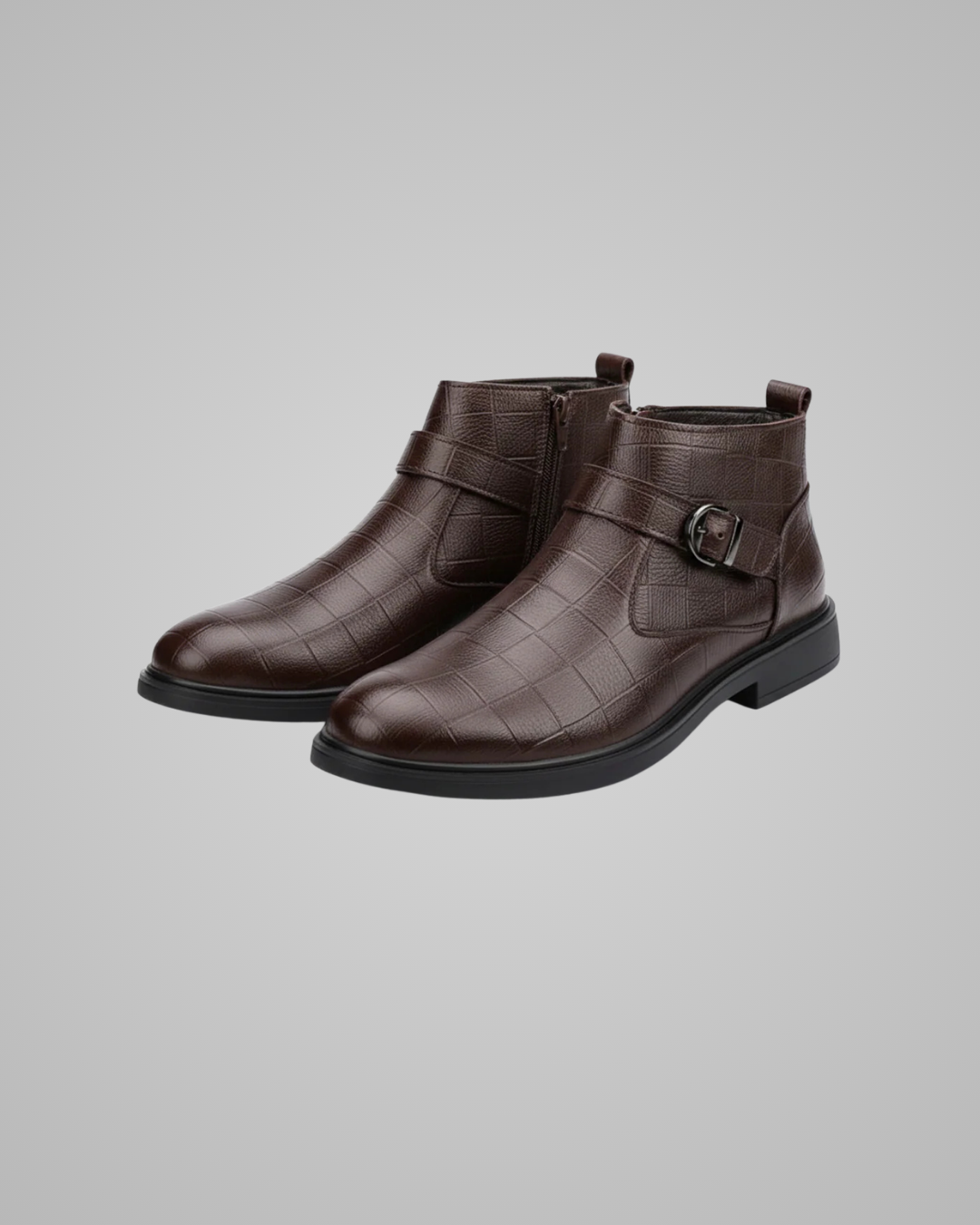 Pair of brown leather boots with buckles on a gray background