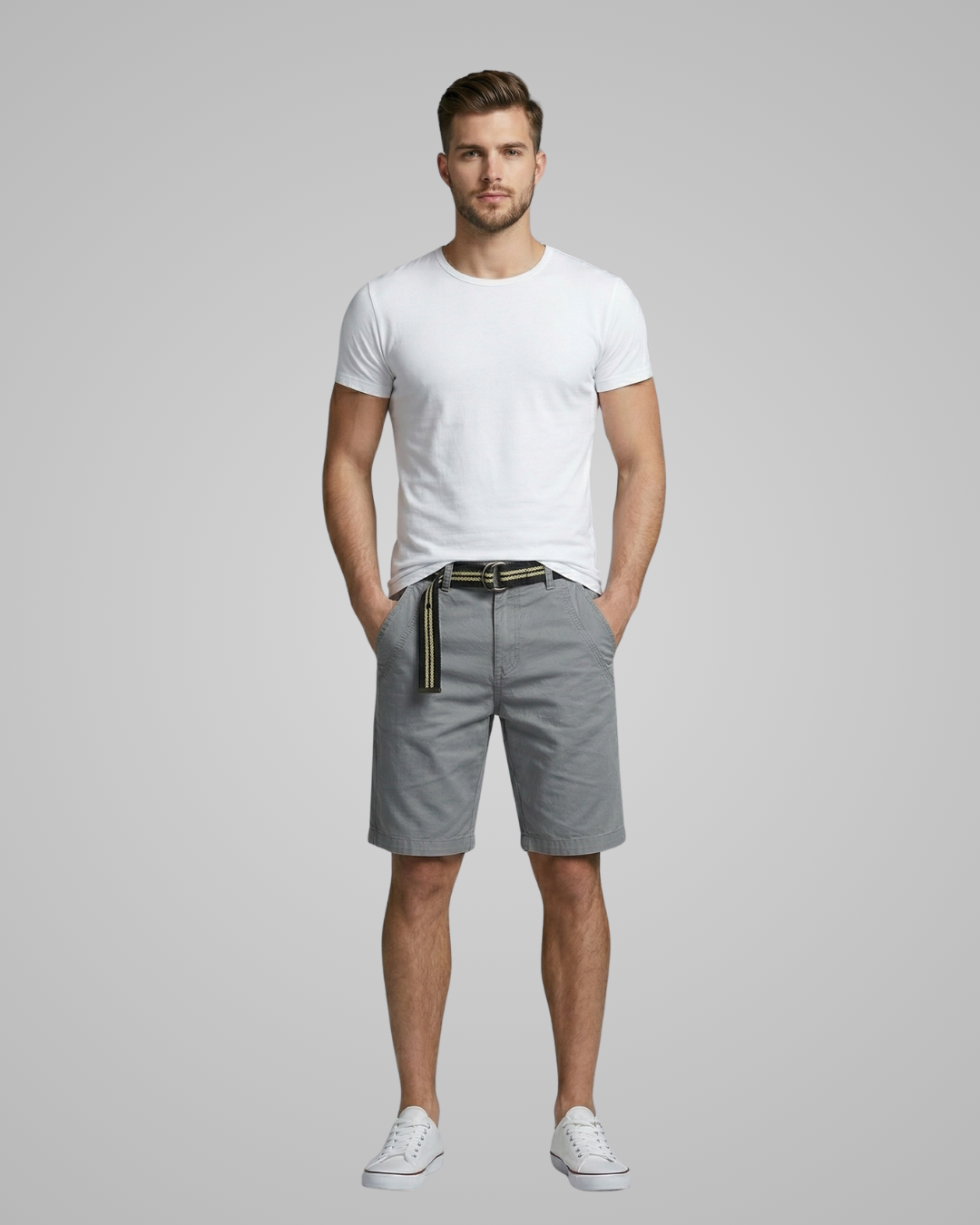 Man wearing a white t-shirt and gray shorts on a plain background