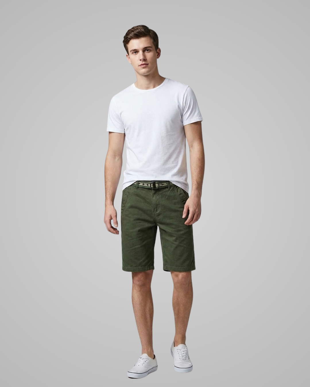 Man wearing a white t-shirt and green shorts on a gray background
