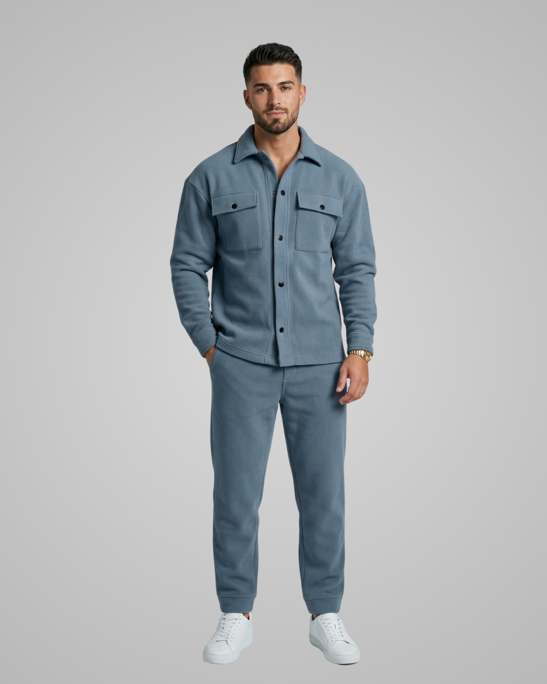 Man wearing a blue outfit with a matching jacket and pants on a gray background
