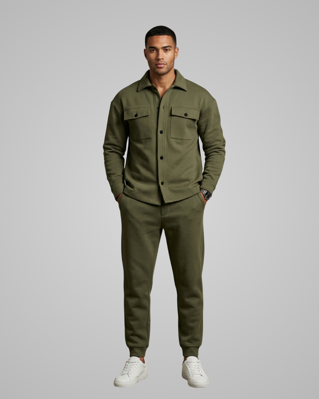 Man wearing a green outfit with a jacket and pants on a gray background