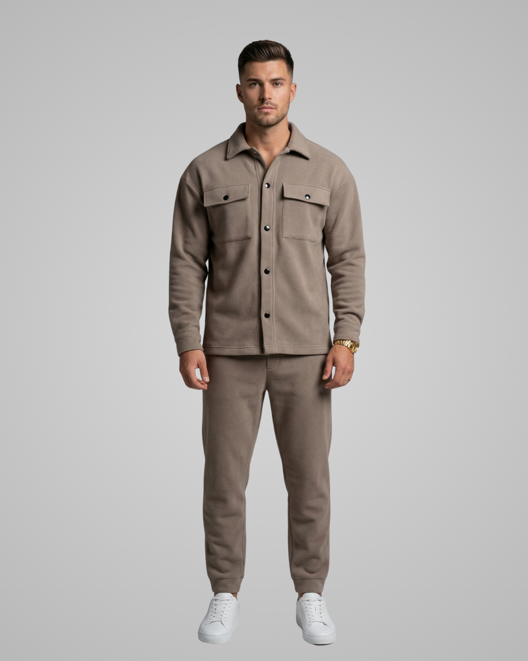 Man wearing a beige shirt and pants set on a gray background