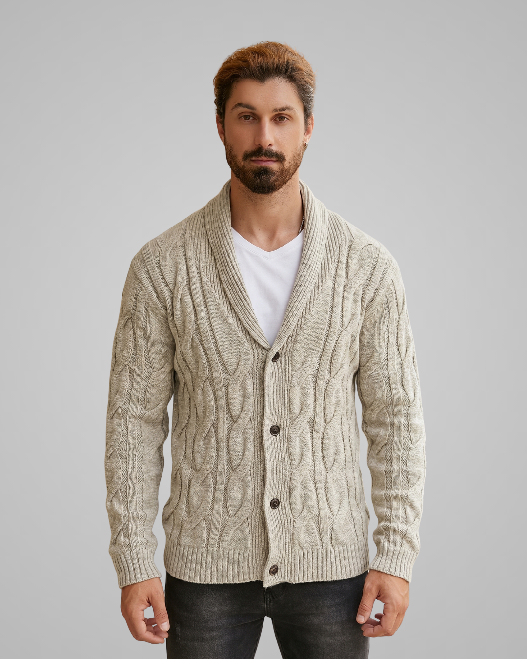 Man wearing a beige cable knit cardigan over a white shirt on a gray background