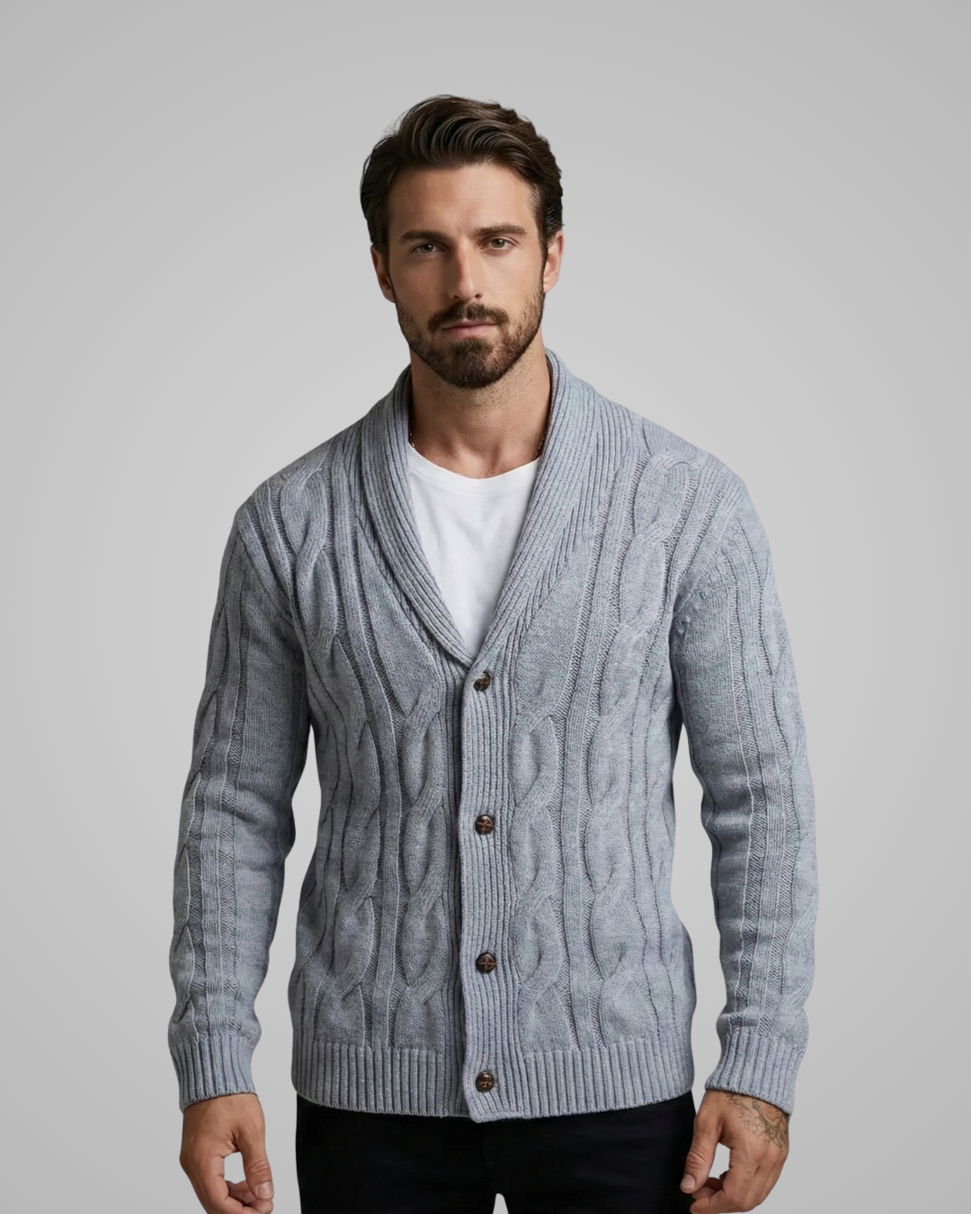 Man wearing a gray cable knit cardigan over a white shirt on a plain background