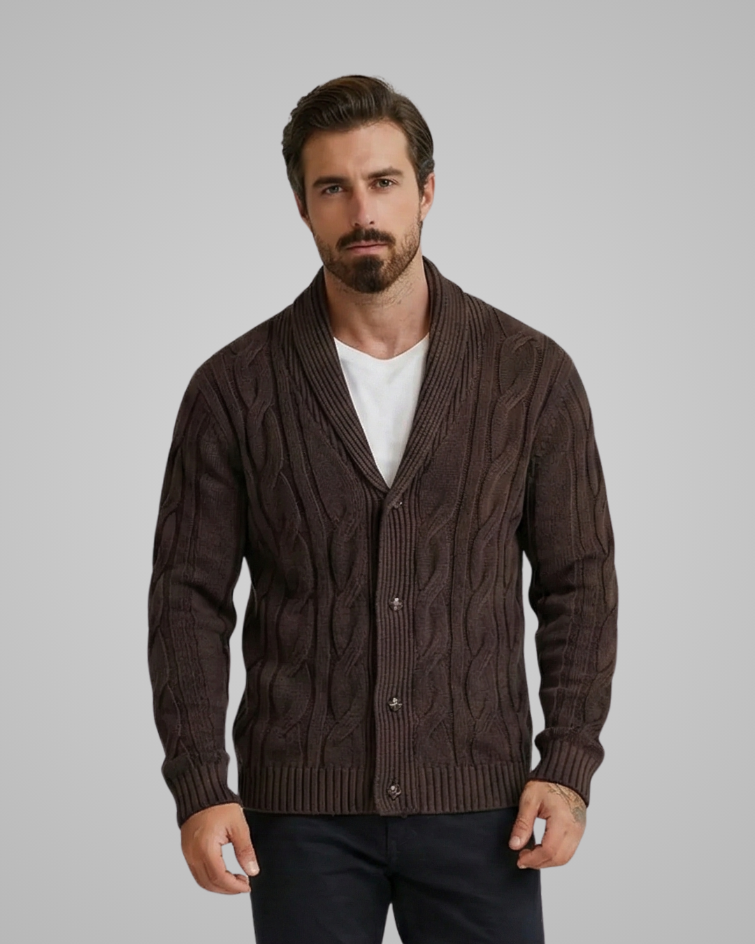 Man wearing a brown cable knit cardigan over a white shirt on a gray background