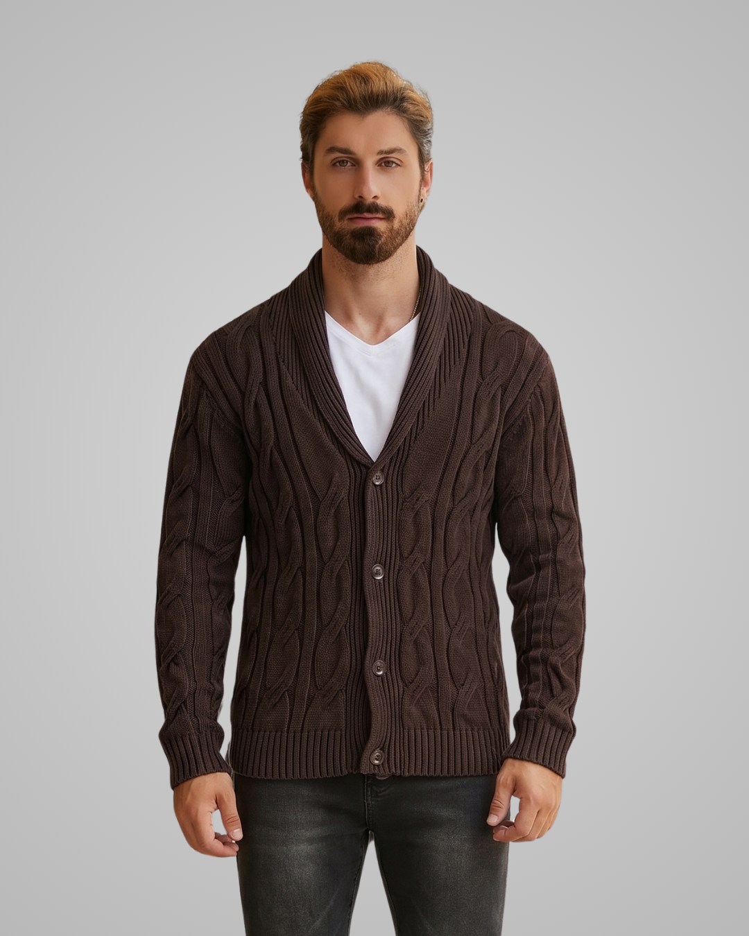 Man wearing a brown cable knit cardigan over a white shirt on a gray background