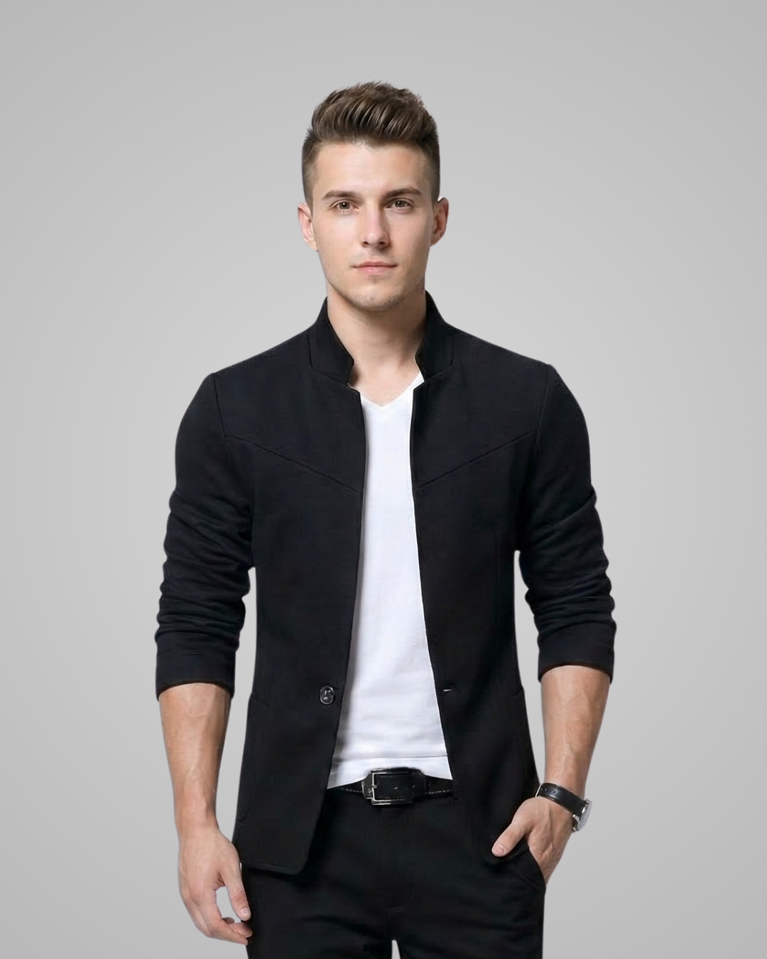 Man wearing a black jacket over a white shirt on a gray background