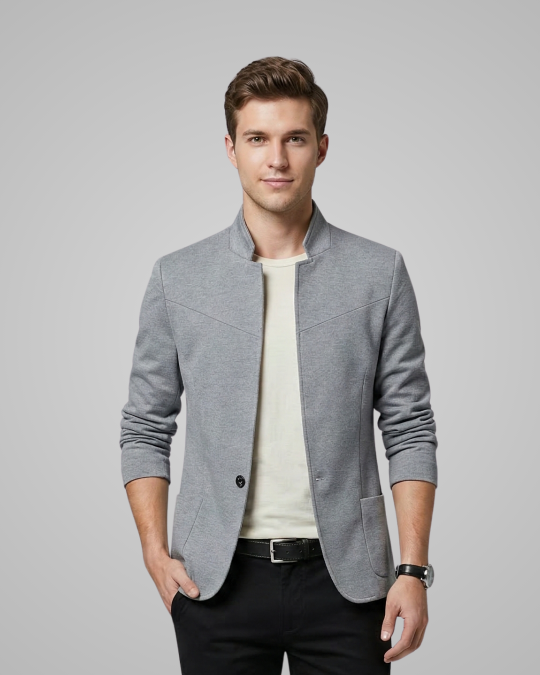 Man wearing a gray blazer over a white shirt on a gray background