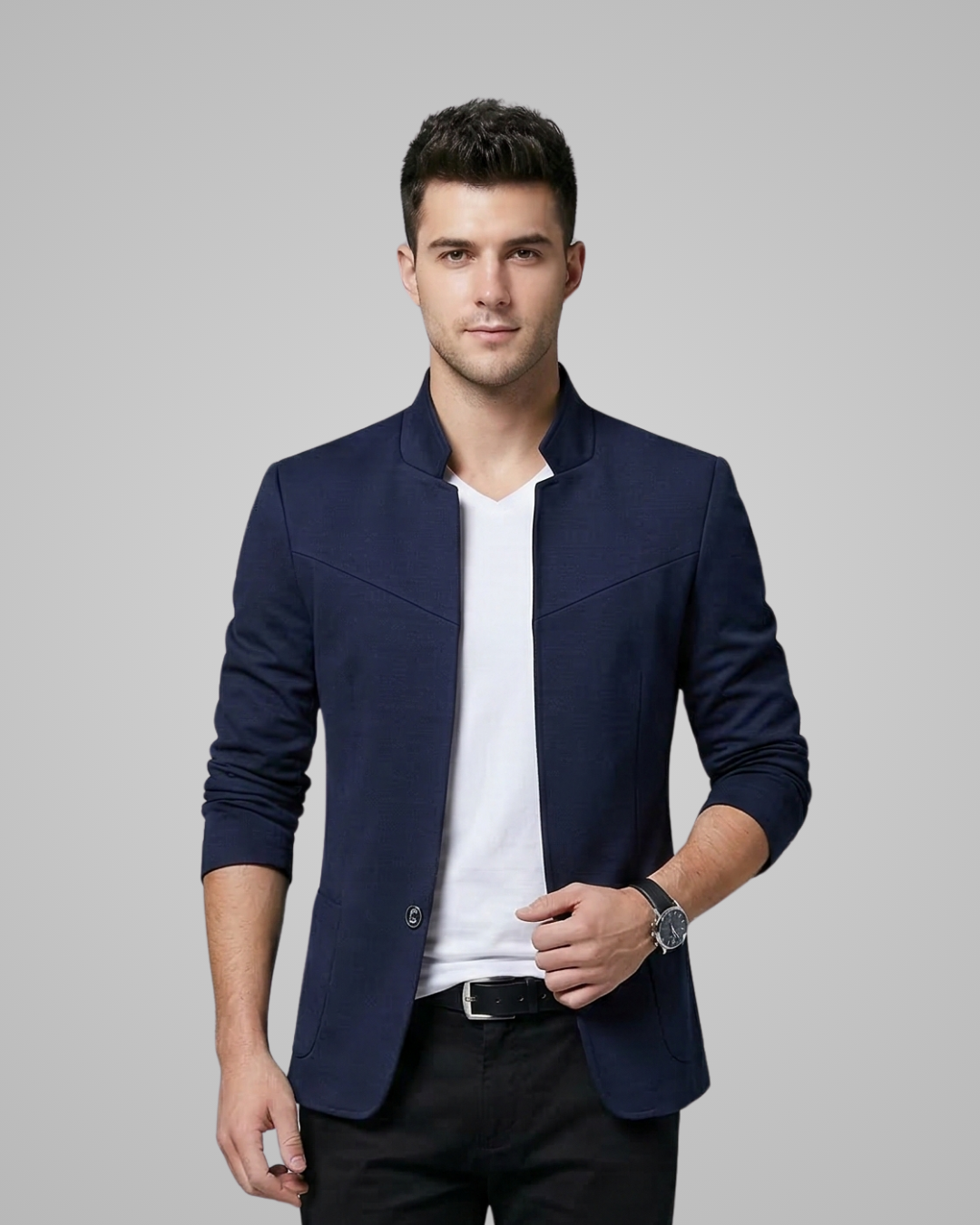 Man wearing a navy blazer over a white shirt on a gray background